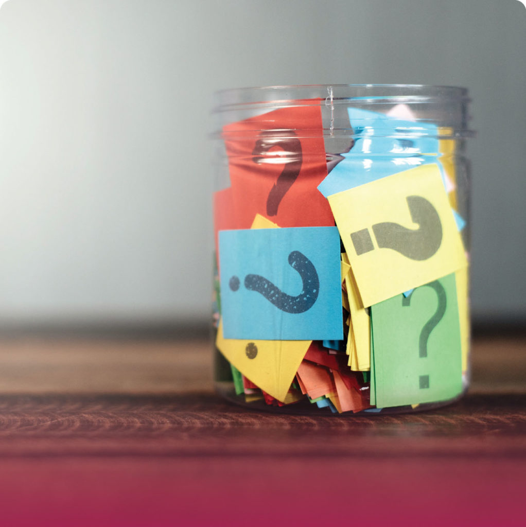 questions marks on paper stuffed in a glass jar